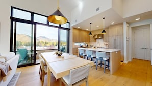 Una cocina moderna con armarios de madera, una isla central e iluminación colgante.