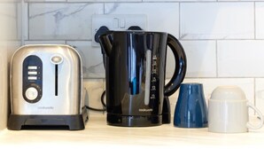 A kitchen counter with a toaster, a coffee maker, and a mug. - Wonderful Holiday Studio in the Trendy Brick Lane (London)