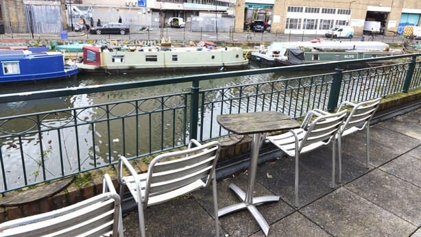 A riverside café with outdoor seating and a view of boats on the water. - Apartment With Canal View in Broadway Market (London)