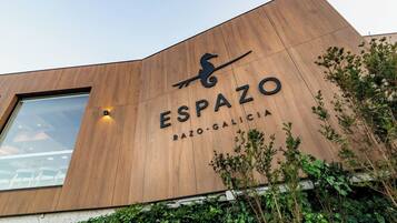 Un edificio con fachada de madera y el nombre "ESPAZO" bien visible.