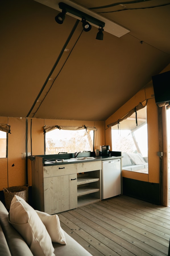 A compact kitchen with a sink, stove, and storage cabinets. There is a window providing natural light and a view of the outdoors. - Espazo (Carballo)