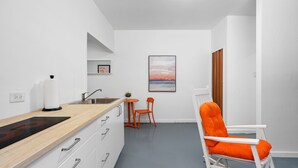 A compact kitchen with a wooden countertop, a sink, and a small dining area with a table and two chairs. - Otium Rentals Condado Space Near Attractions (San Juan)