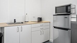 Une cuisine moderne équipée d’un réfrigérateur en acier inoxydable, d’un four à micro-ondes, d’un évier et d’un grille-pain.