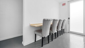 A dining area with a wooden table and four grey upholstered chairs. - Otium Rentals Spacious Apartment in Condado (San Juan)