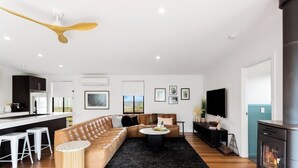 Un salon moderne avec un canapé, une table basse et une cheminée.