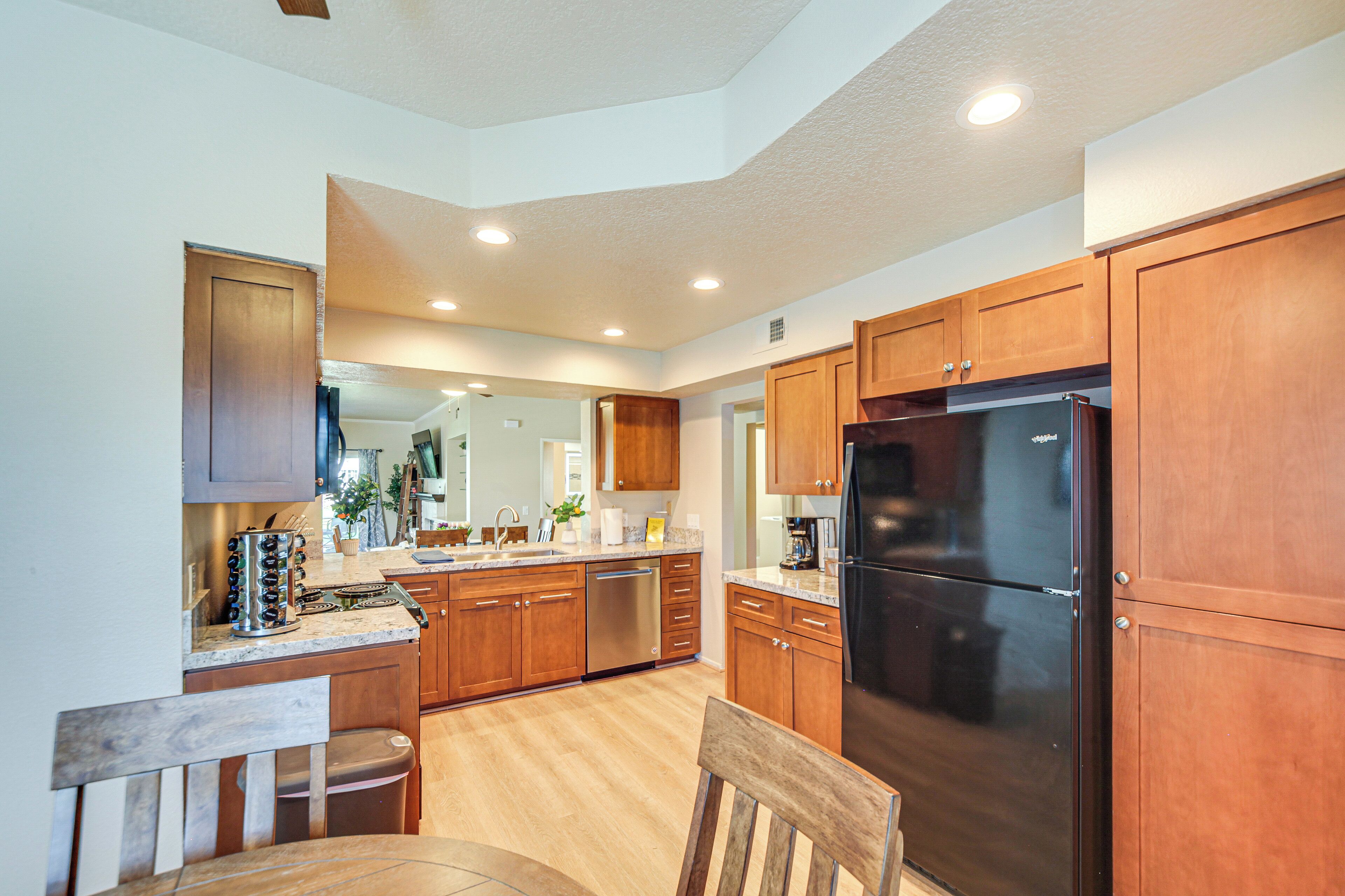 A modern kitchen with wooden cabinets, stainless steel appliances, and a central island.