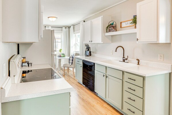 A modern kitchen with white cabinets, a dishwasher, and a countertop.