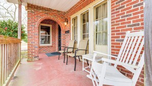 A covered porch with a brick exterior, two white rocking chairs, and a small table. - Sanford Vacation Rental ~ 1 Mi to Downtown! (Sanford)