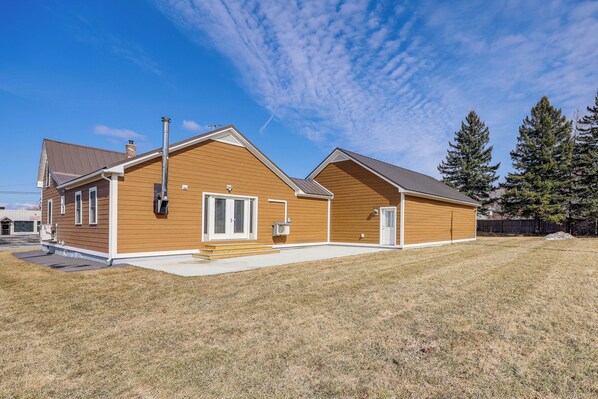 A two-story house with a brown exterior, a front porch, and a small front yard. - Spacious Presque Isle Home: Walk to Downtown! (Presque Isle)