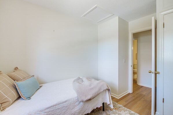 A bedroom with a bed, pillows, and a door leading to a bathroom. - Oxford Getaway: Walk to Oxford Square! (Oxford)