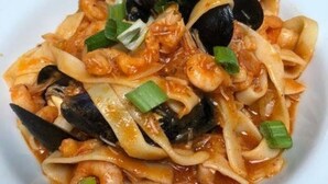 A plate of seafood pasta with mussels, shrimp, and green onions. - Immaculate 2-bed Lodge in Nr Mevagissey (St Austell)