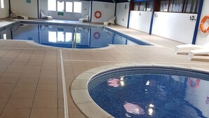 An indoor swimming pool with tiled flooring and a clear water surface. - Immaculate 2-bed Lodge in Nr Mevagissey (St Austell)