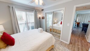 Ein Hotelzimmer mit einem großen Bett, einem Spiegel, einem Schreibtisch und Blick auf die Stadt.