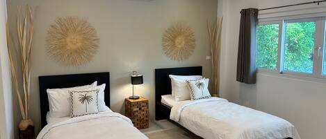 A modern bedroom with two beds, a standing lamp, decorative wall art, an air conditioner, and a window with curtains.