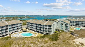 Un hôtel situé en bord de mer, composé de plusieurs bâtiments, doté d’une piscine centrale et offrant une vue sur l’océan.