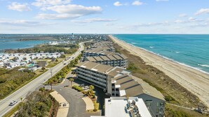 Un hôtel situé sur la côte, composé de plusieurs bâtiments, doté d’un parking et offrant une vue sur la plage.