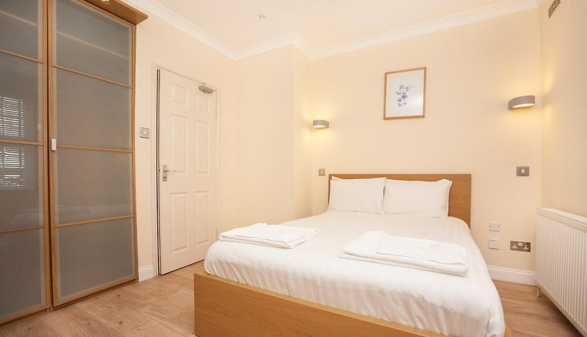 Une chambre d’hôtel avec un lit, une armoire et une porte.