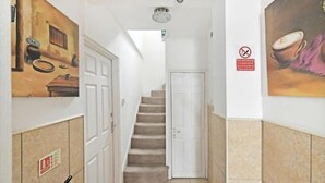 A hallway with a staircase, white doors, and a no-smoking sign. - Captivating 1-bed Apartment in London (London)