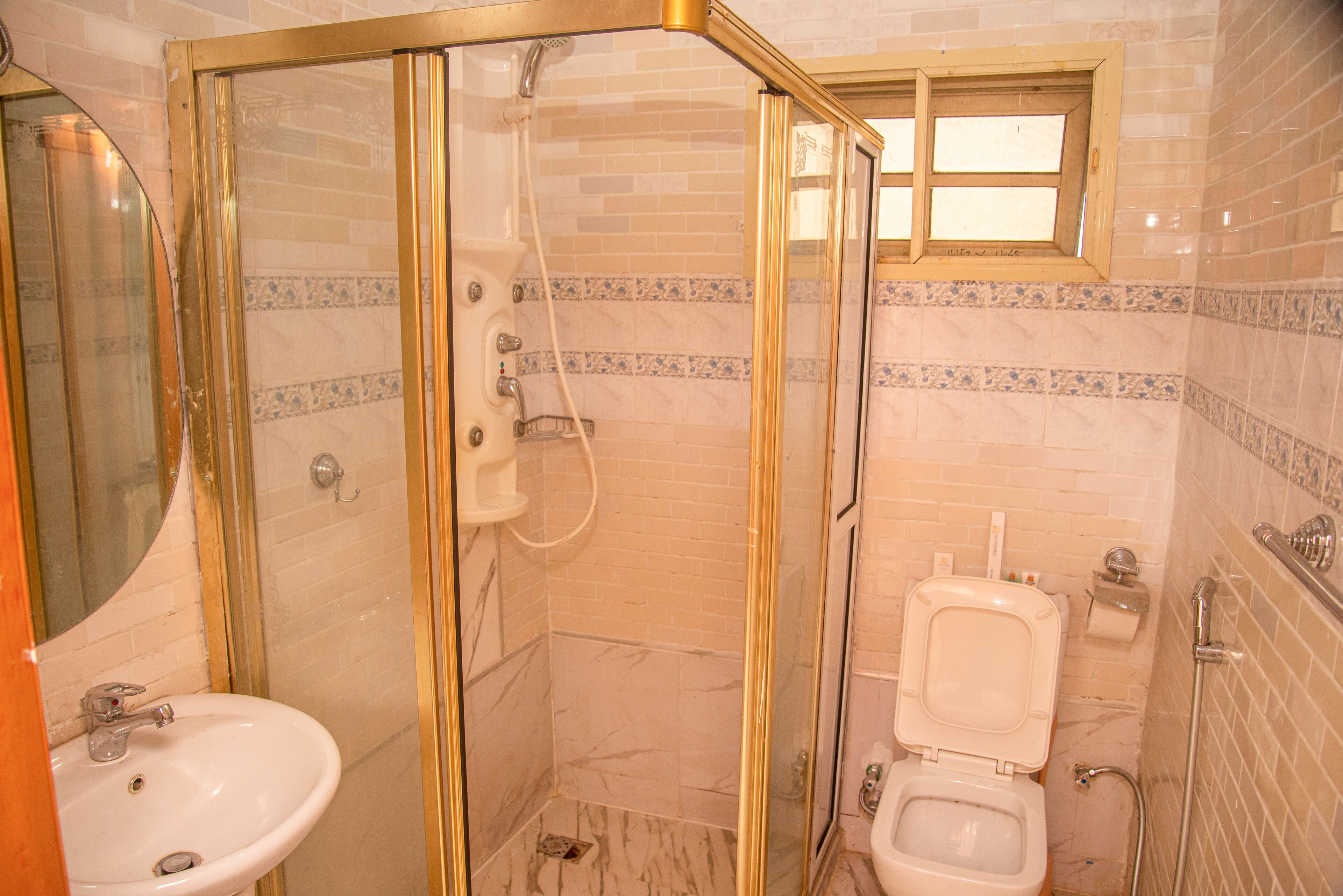A bathroom with a glass-enclosed shower, a sink, and a toilet.