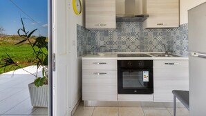 A modern kitchen with light wood cabinets, a patterned backsplash, and a built-in oven. - 3771 Villino Cento Passi by Barbarhouse (Nardò)
