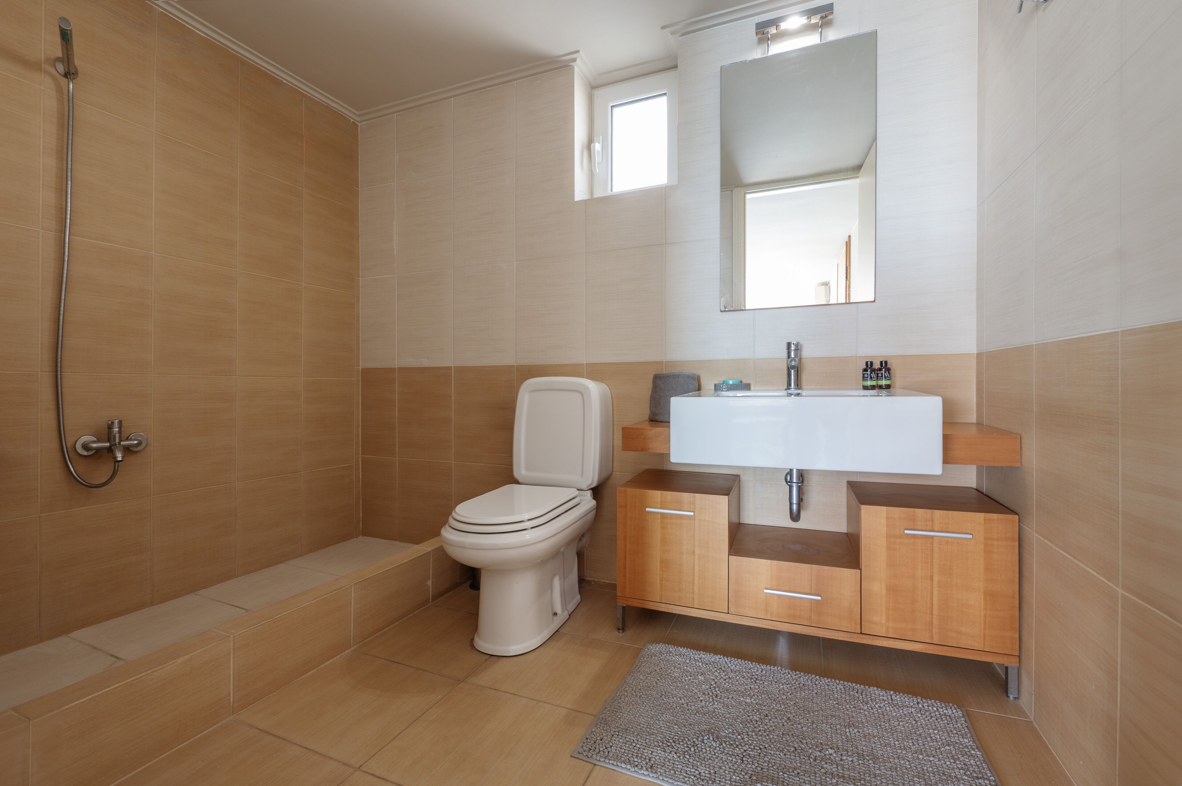 A modern bathroom with a shower, toilet, sink, and vanity.