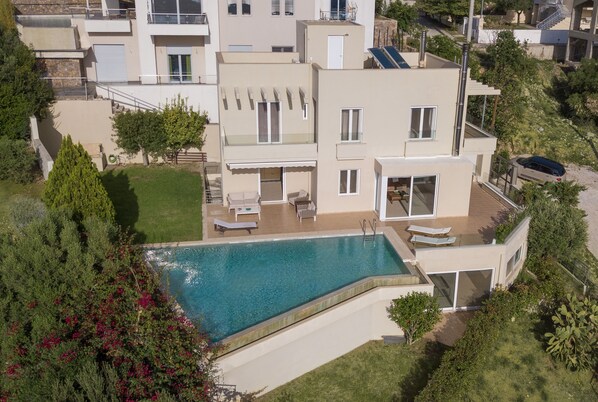 A modern two-story house with a swimming pool, outdoor seating, and a well-maintained garden. - VILLA SERENITY (Saronida)