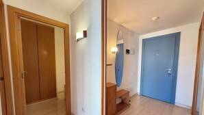 A room with wooden flooring, a blue door, and a wooden cabinet. - Agi Port Canigo 206 Apartamento for rent in Roses Girona. (Roses)
