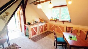 Une cuisine chaleureuse avec des meubles en bois, une table à manger et une fenêtre donnant sur un espace verdoyant.