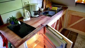 Une cuisine équipée d’une cuisinière intégrée, d’une machine à café et d’un évier.