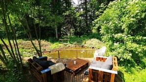 Un espace extérieur aménagé avec du mobilier en bois et un petit étang.