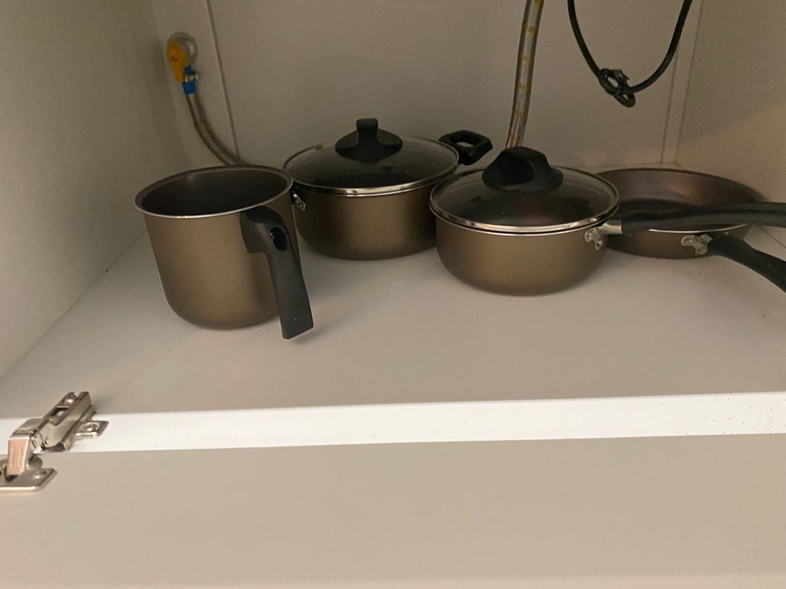 A kitchen with stainless steel cookware including pots and pans.