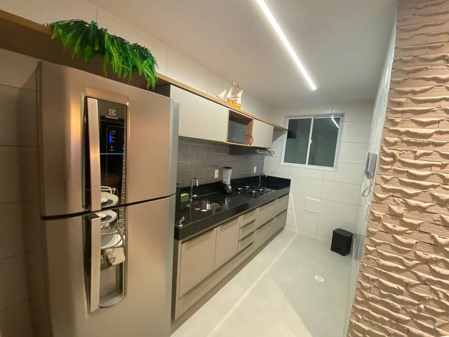 Una cocina moderna con un refrigerador de acero inoxidable, una encimera negra y un ventanal con vistas.