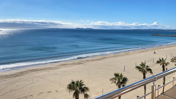 A beach with a clear sky, calm sea, and a distant mountain range. - Agi Europa 62 Apartamento for rent in Roses Girona. (Roses)