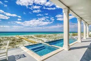 A pool area with clear blue water, a sandy beach, and a view of the ocean. - Brand New 6 BR, 6.5 BA | Gulf Front Home | Private Pool | Hot Tub | Sleeps 18 (Pensacola Beach)