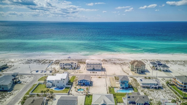 A coastal residential area with beachfront properties, including houses with swimming pools and a beach access road. - Brand New 6 BR, 6.5 BA | Gulf Front Home | Private Pool | Hot Tub | Sleeps 18 (Pensacola Beach)