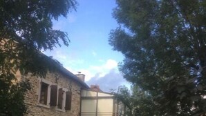 A stone building with a central archway and a stone pathway leading to it. - Gite à la Campagne (Quins)