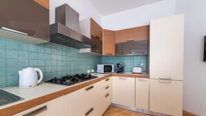 Een moderne keuken met een gasfornuis, een magnetron en een koffiezetapparaat.