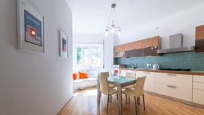Een moderne keuken met houten kastjes, een gasfornuis en een betegelde spatwand.