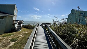 A wooden boardwalk leading to a beach with a clear sky and ocean view. - Beach Retreat: Walk to Beach & Pool, Sleeps 12, Pet Friendly (Port Aransas)