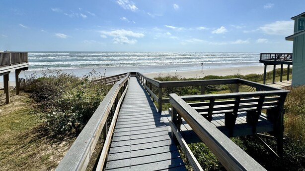 A wooden boardwalk leading to a beach with a clear view of the ocean. - Beach Retreat: Walk to Beach & Pool, Sleeps 12, Pet Friendly (Port Aransas)