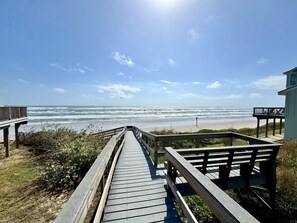 A wooden boardwalk leading to a beach with a clear view of the ocean. - Beach Retreat: Walk to Beach & Pool, Sleeps 12, Pet Friendly (Port Aransas)