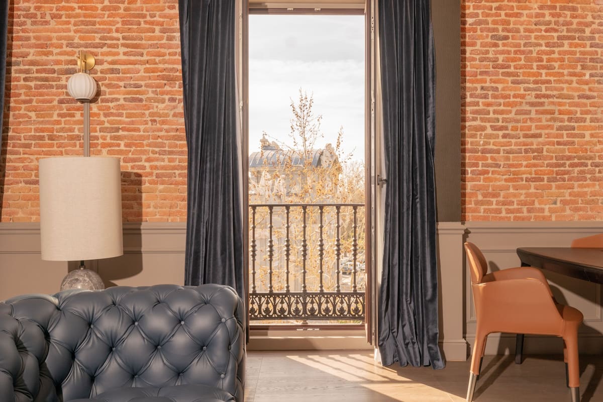 Relax in a stylish space with a comfortable sofa, dining table, and balcony offering a view of the surrounding architecture.