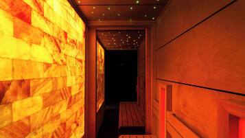 A narrow hallway with wooden benches and a wall with a warm, glowing pattern.