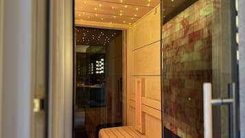 A modern bathroom with a wooden vanity, a glass shower enclosure, and a patterned wall.