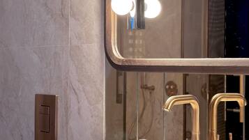 A bathroom with a large mirror, vanity, and dual sinks.