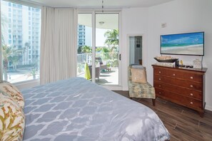 Une chambre d’hôtel avec un lit, une commode, une chaise et un téléviseur.