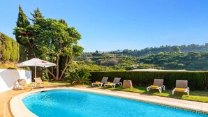 A swimming pool with lounge chairs and a view of a hilly landscape. - Villa Casa Tania by Villa Plus (Frigiliana)