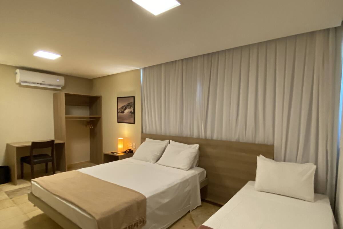 Ein Hotelzimmer mit zwei Betten, einem Schreibtisch und einem Stuhl.