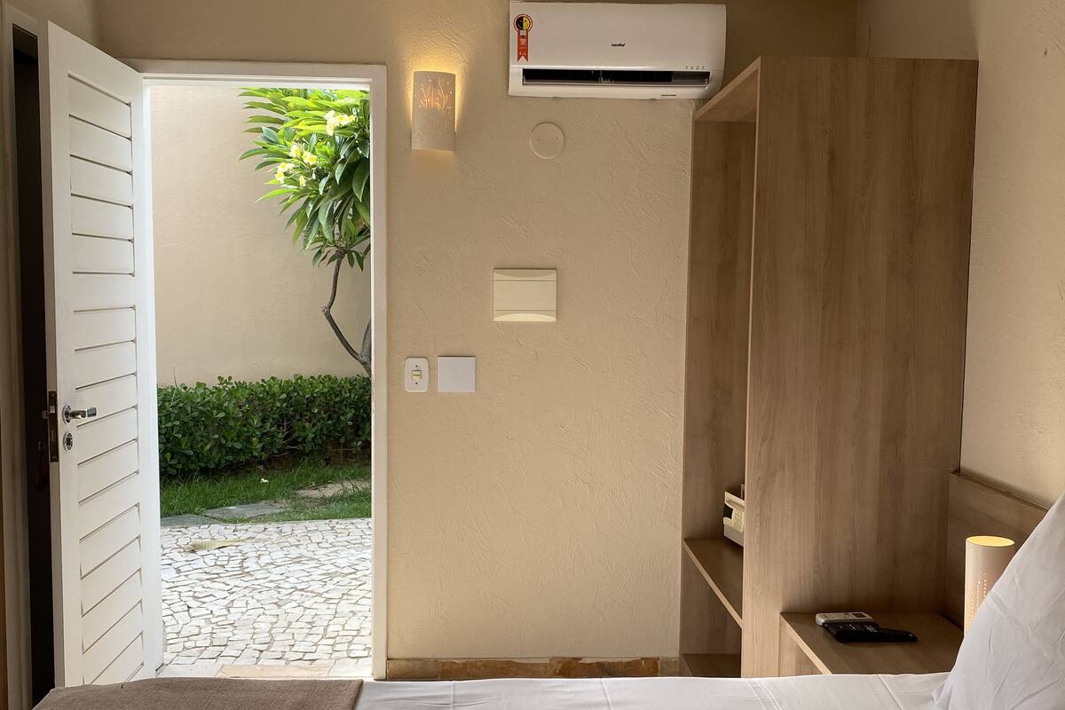 Ein Hotelzimmer mit Bett, Nachttisch und Klimaanlage.