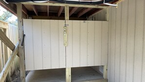 A wooden structure with a metal door and a small wooden platform at the entrance.